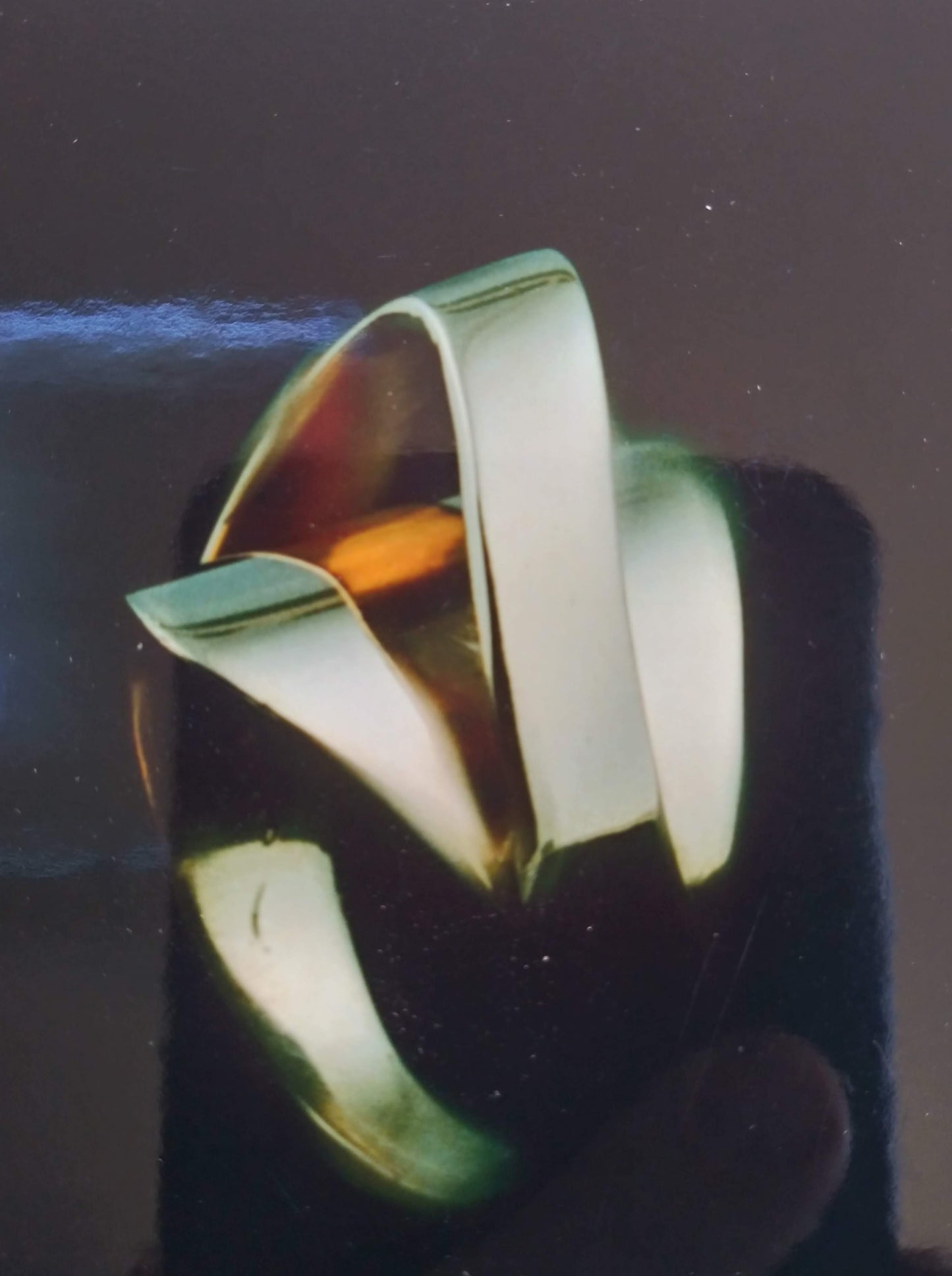 A silver ring with an amber-colored gemstone held in place by two curved bands of silver